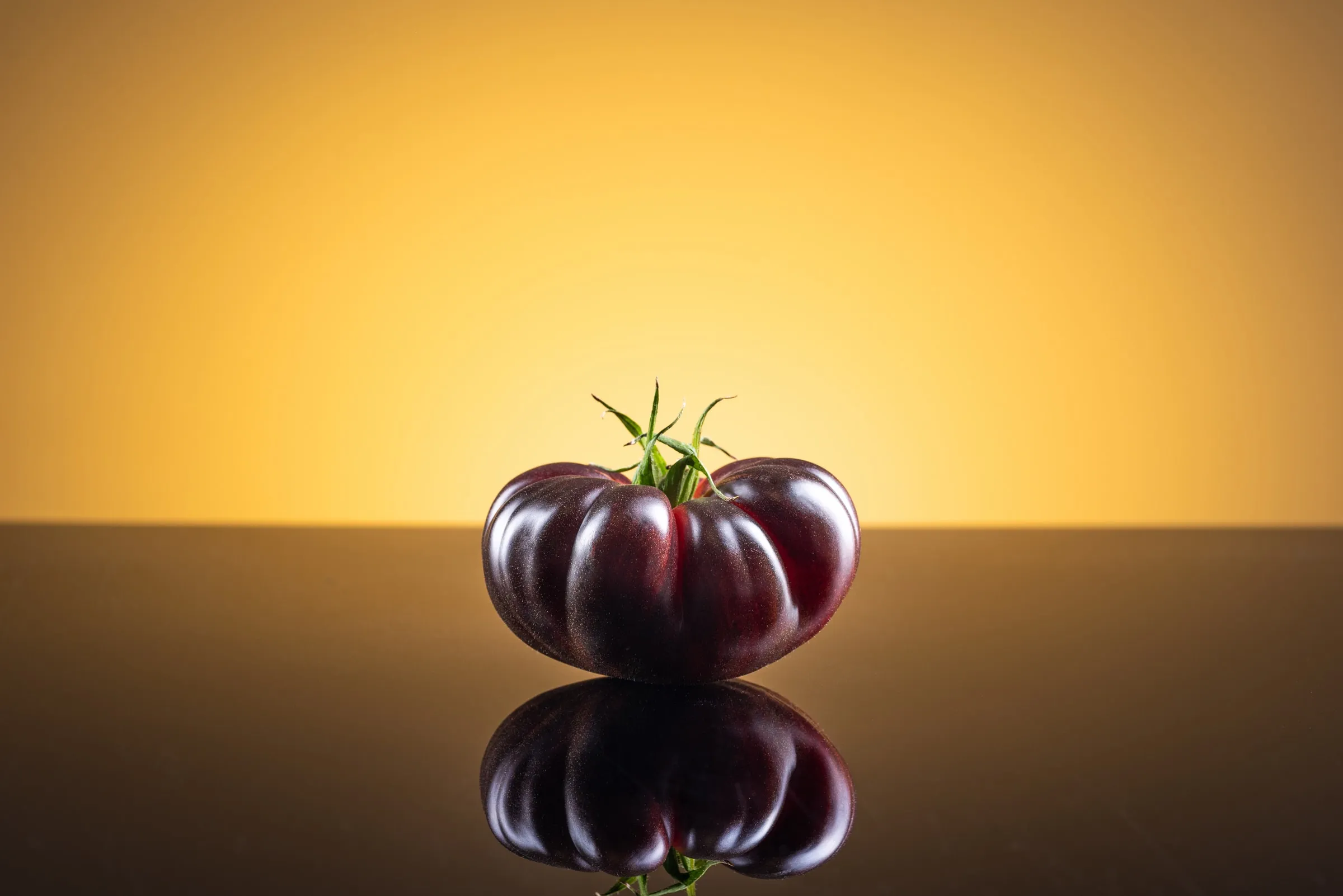 Tomate Mystika entero sobre un fondo cálido de tono ámbar.